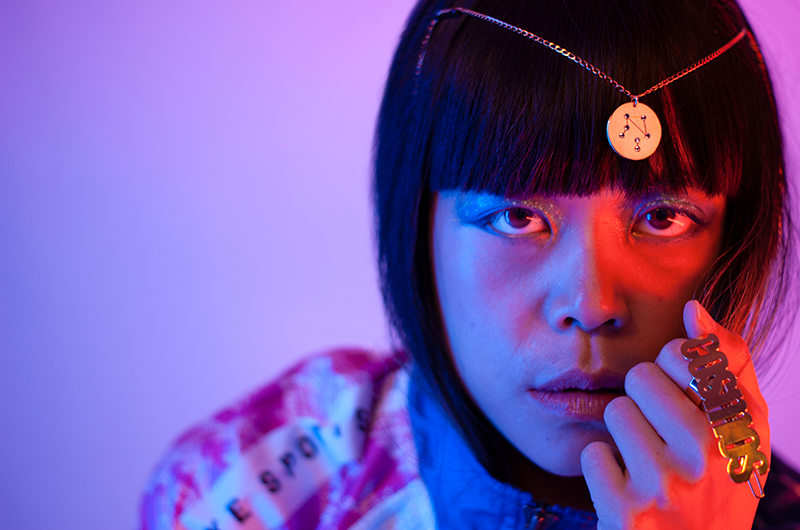 Asian model artistically wearing 18k gold plated necklace