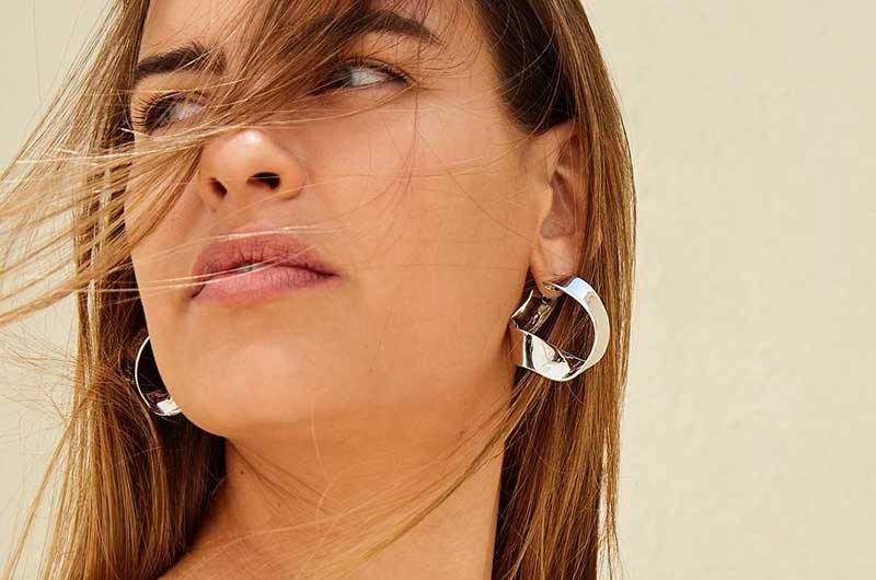 Fashion model wearing silver plated twisted hoop earrings