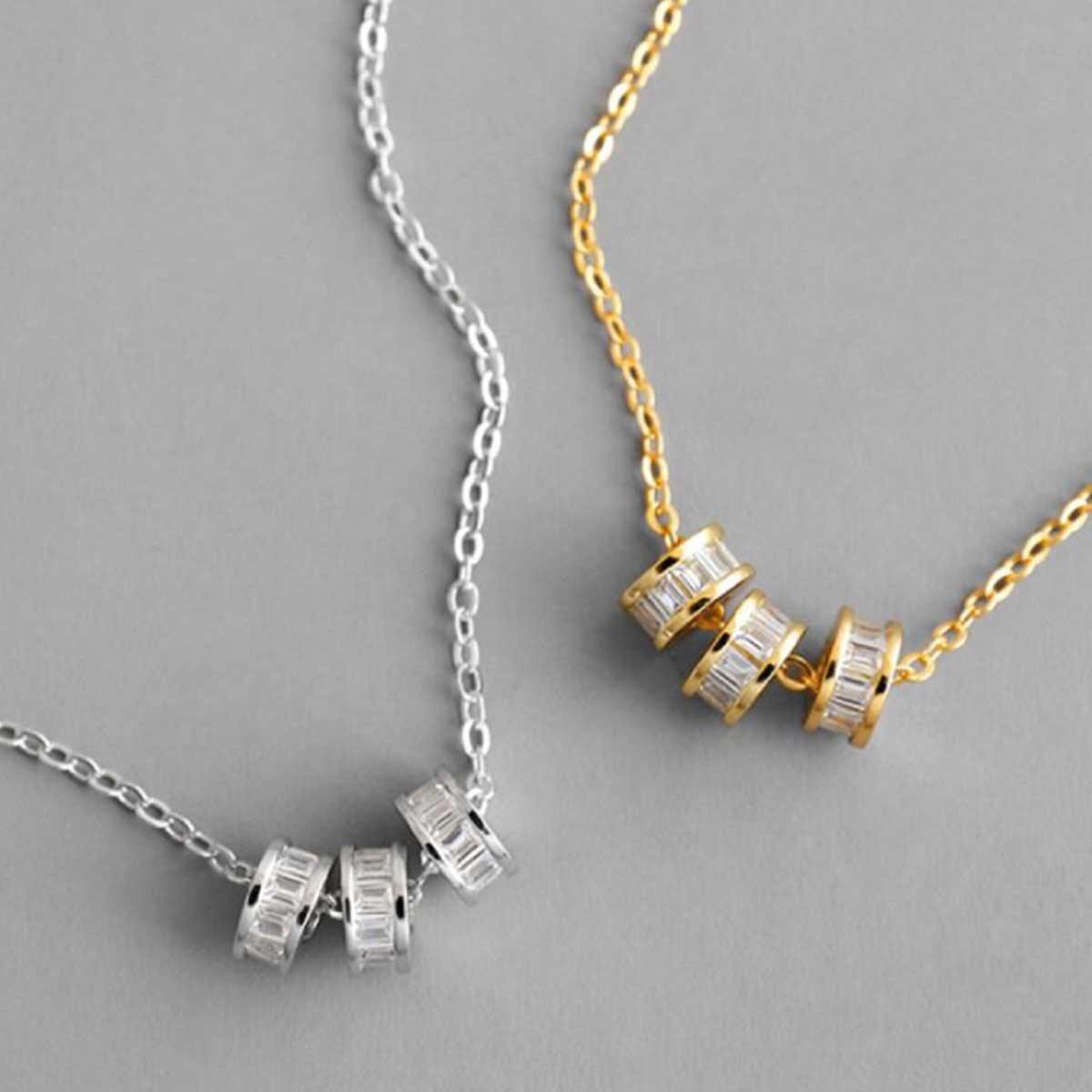 Flattering gold and silver plated necklaces with three dainty wheel shaped charms studded with white cubic zirconias handmade from sterling silver